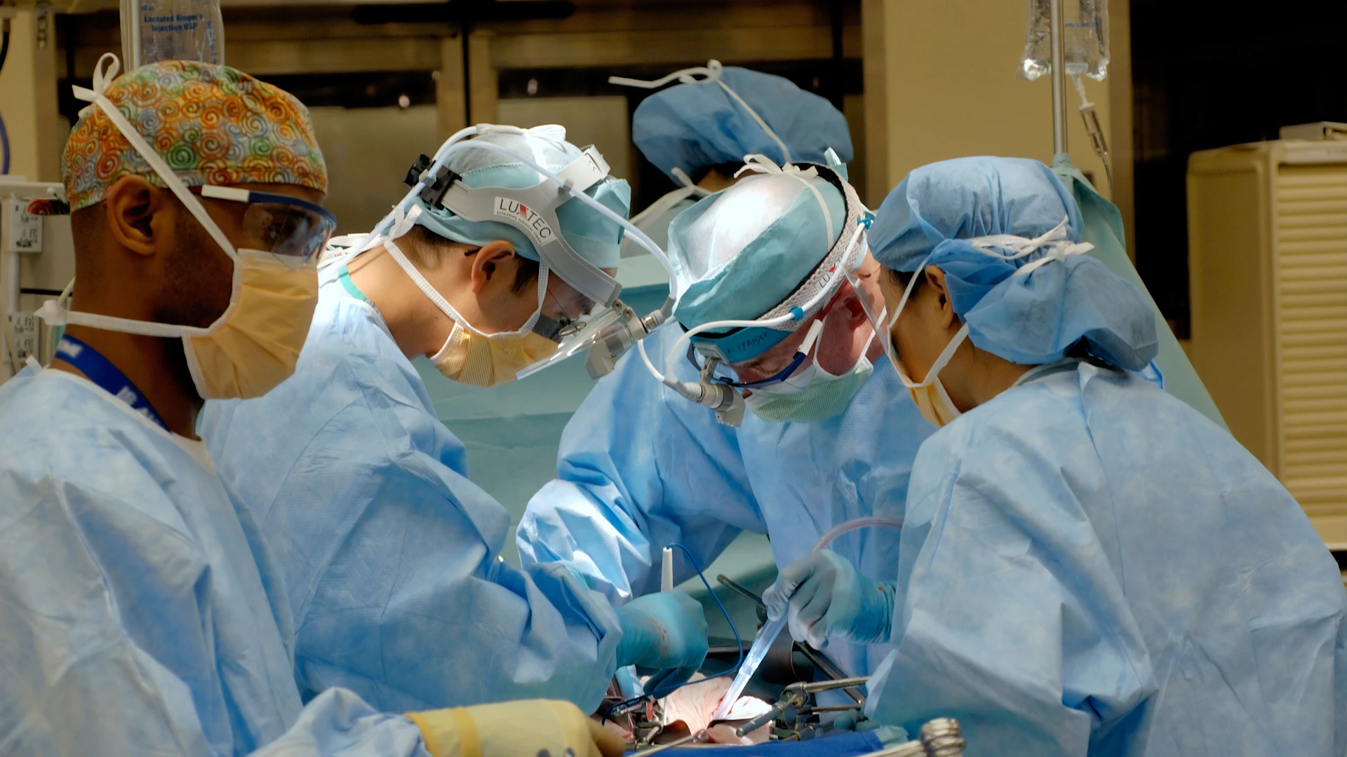 Surgical team performing an operation in a bright theatre
